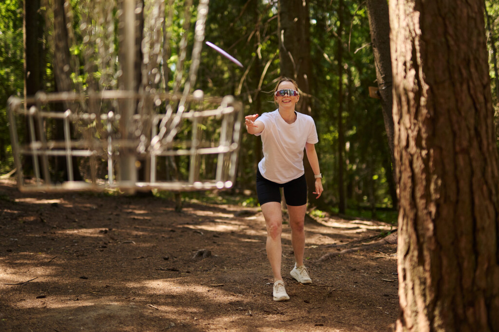 Jente kaster frisbee-golf